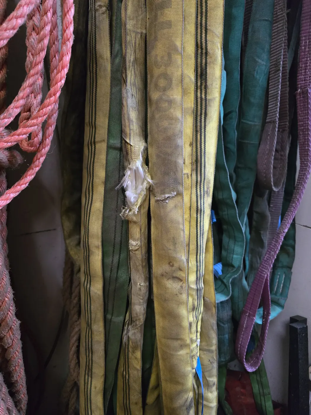 Beschädigtes textiles Hebeband mit deutlichen Scheuerstellen