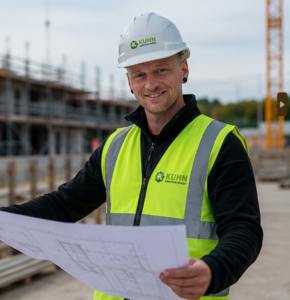 Janis Kuhn mit Bauplan auf einer Baustelle